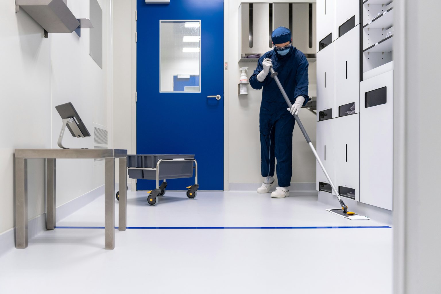 Laboratory cleanroom with a worker maintaining the floor