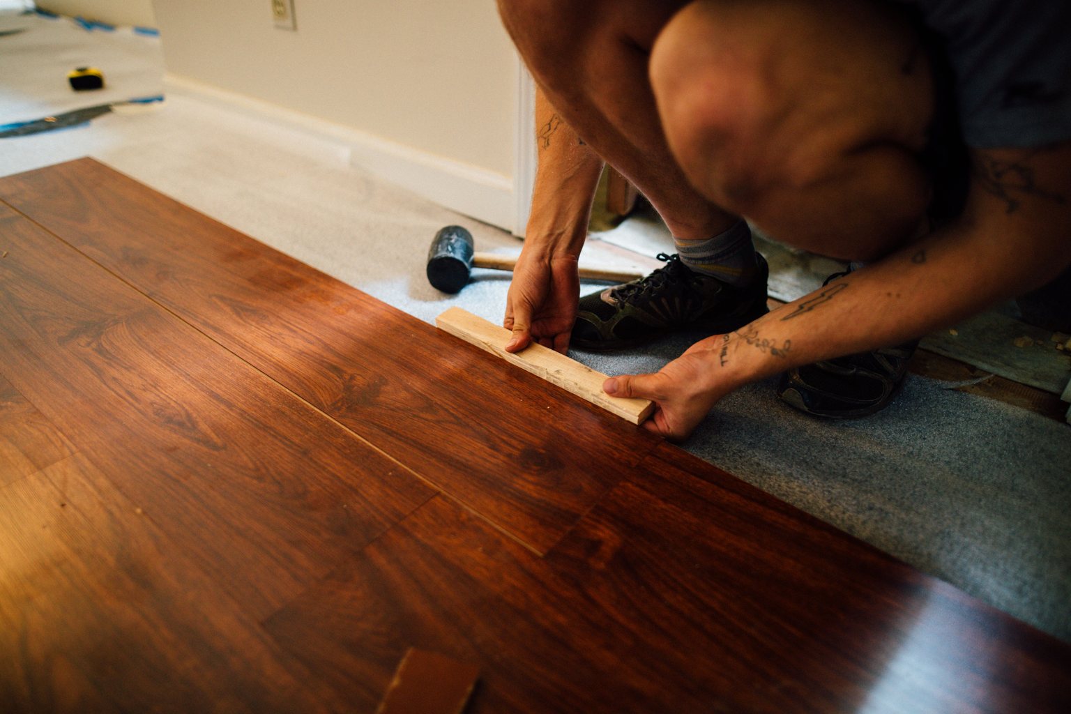 Installer fitting wood-look planks over an exposed underlayer