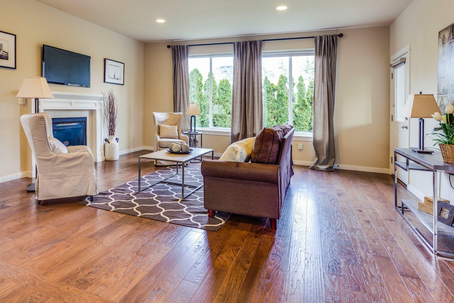 Living room with a fireplace and warm wood flooring